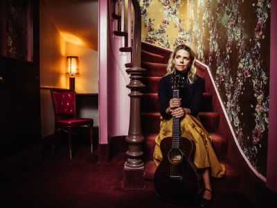 Aoife O'Donovan sat on staircase holding a guitar